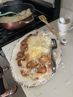 a pan filled with food sitting on top of a counter next to a frying pan