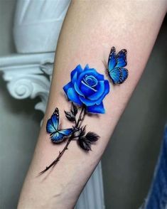 a blue rose and two butterflies on the arm