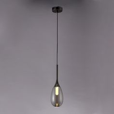 a light bulb hanging from the ceiling in an empty room with grey walls and flooring