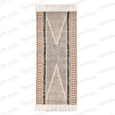 a beige and black rug with fringes on the bottom, in front of a white background