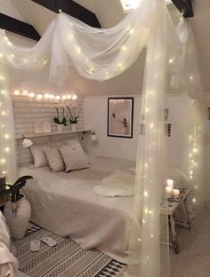 a white bedroom with lights on the ceiling and bed canopy over it's headboard