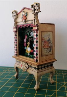 a miniature clock is sitting on a green table top with yellow and white checkered tiles