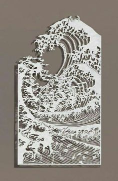 an intricate cut out of paper with waves on it