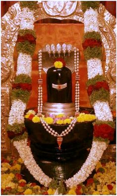 a statue with flowers and pearls around it