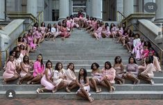 a group of women in pink dresses sitting on steps