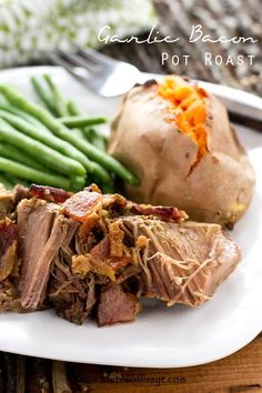 a white plate topped with meat and green beans