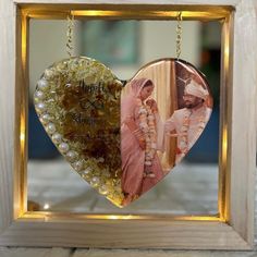 a heart shaped ornament hanging from a frame with a photo in the middle