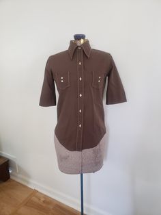 This vintage shirt is perfect for any retro wardrobe. Take #1 Circa 1970s 60% cotton / 40% polyester The shirt is a chocolatey shade of brown. Shoulder to shortest hem point: 20.5 inches Sleeve length: 10.75 inches Chest: 34 inches This shirt is in very good vintage condition with minor wear and age. Feel free to send me any questions! Retro Wardrobe, Dark Chocolate Brown, Clothing Casual, Vintage Shirt, Womens Casual Outfits, Casual Everyday, Vintage Shirts, Chocolate Brown, Dark Chocolate