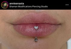 a woman's lip with a heart shaped piercing on it