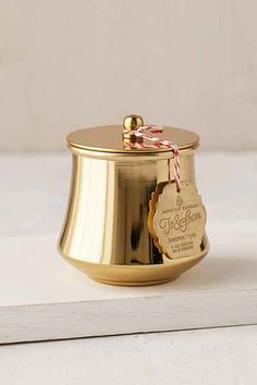 a gold canister sitting on top of a white table