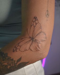 a woman's arm with a butterfly tattoo on it