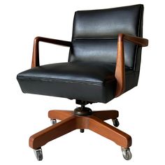 a black leather office chair with wooden arms and casteor wheels on an isolated white background