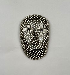 a black and white mask with dots on it