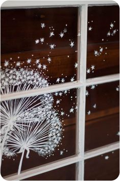 a white dandelion sitting on top of a window next to a wooden wall