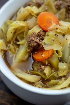 a white bowl filled with meat and vegetable soup