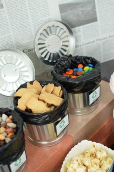 there are many different types of snacks in buckets next to each other on the counter