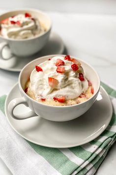 two cups filled with whipped cream and strawberries