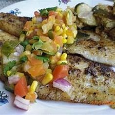 some food is on a white plate with blue and purple designs around it, including corn