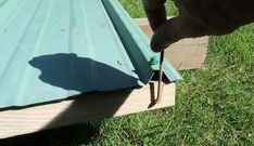 a person using a drill to fix a metal roof