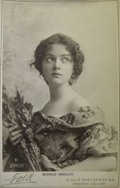 an old black and white photo of a woman holding flowers