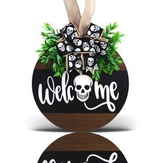 the welcome sign is decorated with skulls and greenery in black, white and brown