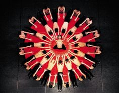 a group of young people standing in a circle with their arms around each other on the floor