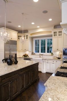 a large kitchen with an island in the middle and marble counter tops on both sides