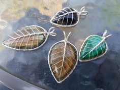 three leaf shaped brooches sitting on top of a car