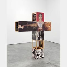 a cross made out of multiple pictures in a room with concrete flooring and white walls