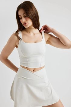 Our sporty take on the fitted and ultra-fem corset. The Corset Tank doubles as a bra and top with 1 ½” shoulder straps, princess seam stitch details, and an inside built-in bra. Made with Recycled Poly. Square scoop neck 15 ½” L Low impact Lined 84% Recycled Polyester 14% Spandex Medium weight with just enough stretch for flexibility 84% Recycled Polyester 14% Spandex Machine wash cold, lay flat dry Made in the USA Stretch For Flexibility, Flair Skirt, Sporty Summer, Corset Tank Top, Stretches For Flexibility, White Corset, Bone Color, Tennis Skort, Cream Style