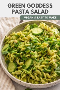 a bowl filled with pasta and cucumbers on top of a striped table cloth