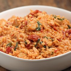 a white bowl filled with rice and meat