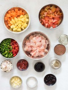 bowls filled with different types of food sitting on top of a white table next to each other