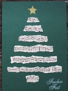 a christmas tree made out of sheet music on a piece of green paper with gold star