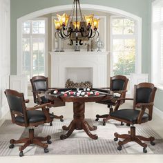 a dining room table with chairs around it and a pool table in front of the fireplace