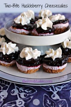 two - bite huckleberry cheesecakes with whipped cream on top