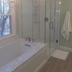 a bathroom with a walk in shower next to a bathtub