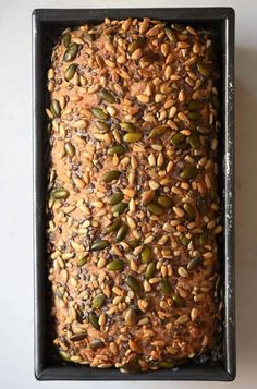 an uncooked loaf of bread with seeds in it on a baking pan, ready to be baked