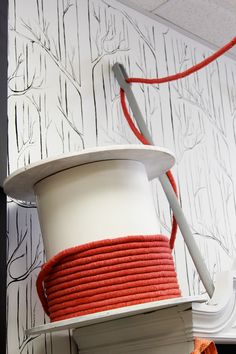 a white and red hat on top of a shelf in front of a wallpaper