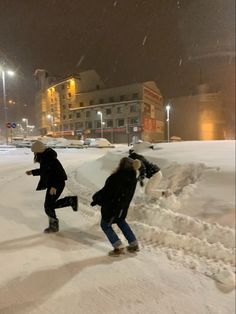 two people walking in the snow at night