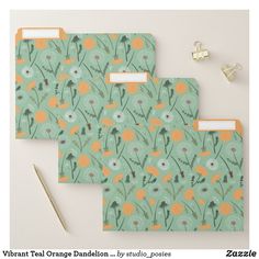 three folders with floral designs on them next to a pen and paper clipboard