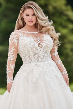 a woman in a wedding dress with long sleeves and flowers on the bouncy