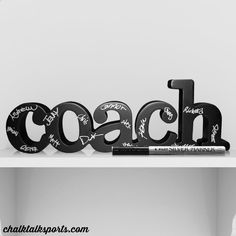 black and white photograph of the word coach written in cursive writing on a shelf