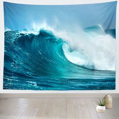 a large blue ocean wave tapestry hanging on a wall