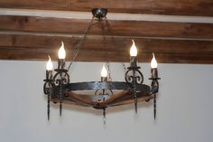 a chandelier hanging from the ceiling with five lights on it and an iron frame