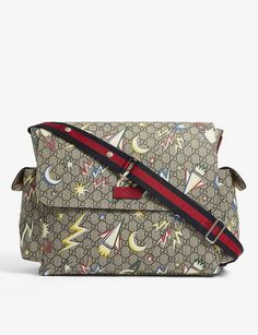 a gucci bag with stars and planes on the front, sitting on a white surface