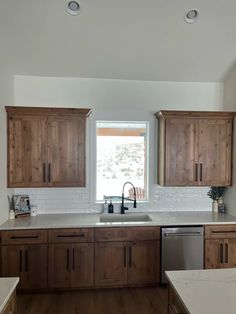 a kitchen with wooden cabinets and white counter tops