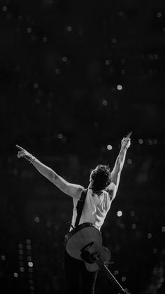 a man is performing on stage with his arms in the air