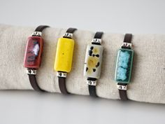 Colorful women's leather bracelet with rectangular ceramic and silver brass beads. Dark brown flat leather and ceramic bracelet in 4 colors with an original speckled effect (turquoise green, burgundy, yellow and beige). Cute bracelet with bright and vivid colors. Unique handmade contemporary boho style summer jewelry. Ideal gift for her, gift for mom, sister, daughter, friend... Important: Always measure your wrist circumference to ensure you have the correct size. Bracelet suitable for wrists from 14 to 16 cm. Outline. (5.5 to 6.3 inches) Care: It can get wet. It is recommended to hydrate the leather with grease or cream if necessary. ELABORATION Each ceramic piece is carefully modeled with white clay and hand painted with special ceramic glazes. Two firings of up to 1200 º C are necessar Minimalist Leather Bracelet Jewelry, Minimalist Leather Bracelet Strap Jewelry, Everyday Leather Bracelet Jewelry, Modern Handmade Bracelets For Everyday, Rectangular Silver Leather Jewelry, Modern Adjustable Rectangular Leather Bracelet, Modern Handmade Jewelry For Everyday Use, Bohemian Rectangular Jewelry For Everyday, Handmade Adjustable Jewelry For Everyday Use