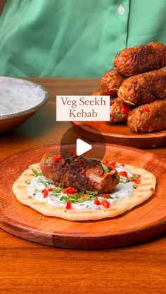 a wooden plate topped with meat covered in sauce